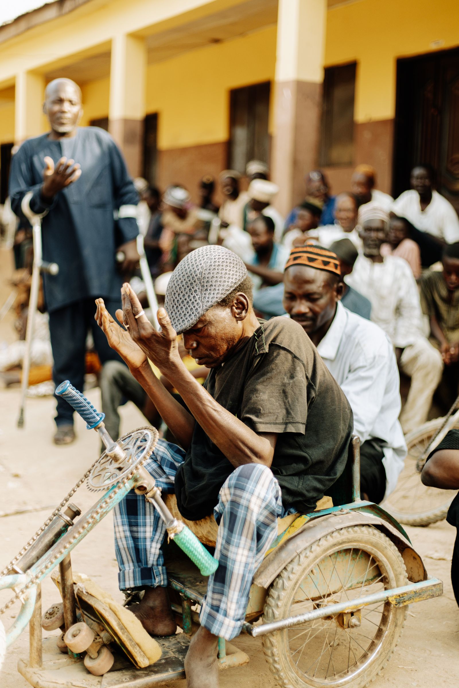 Men with crutches and wheelchairs gathered at a community meeting.